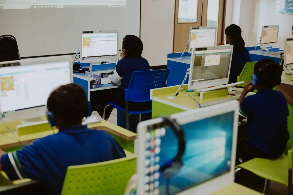 Students using headphones and computers in a classroom